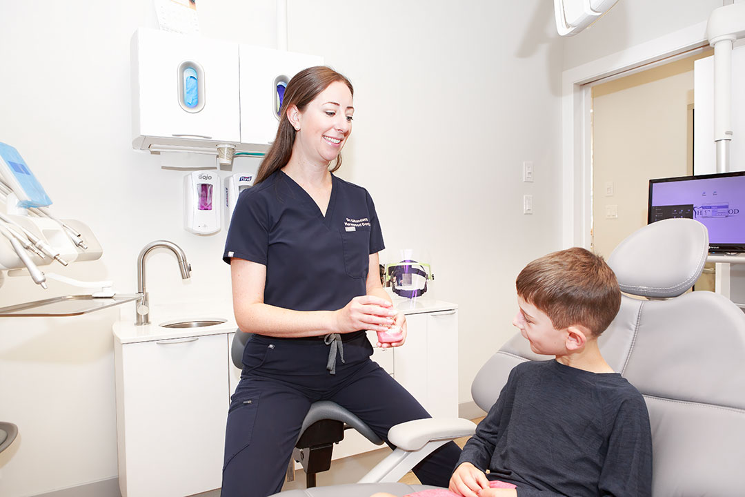 a woman in a dentist uniform holding a bottle of liquid