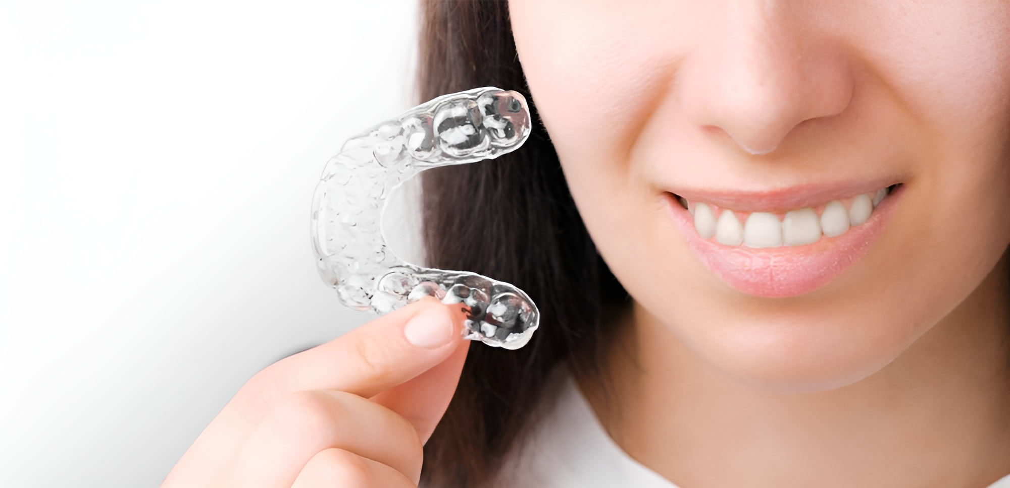 a woman holding a clear plastic retainer