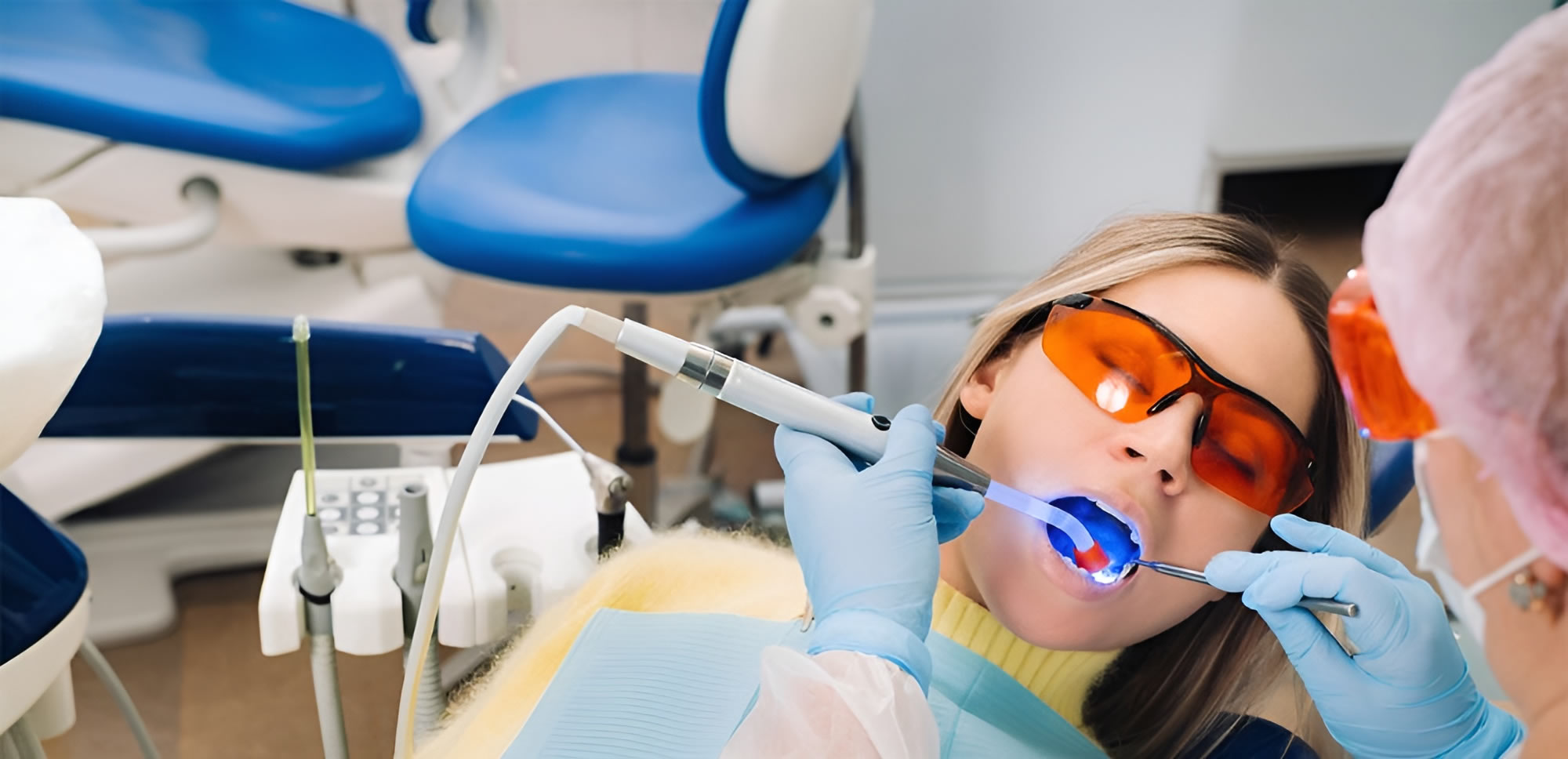 a woman in a dental chair using a dental tool